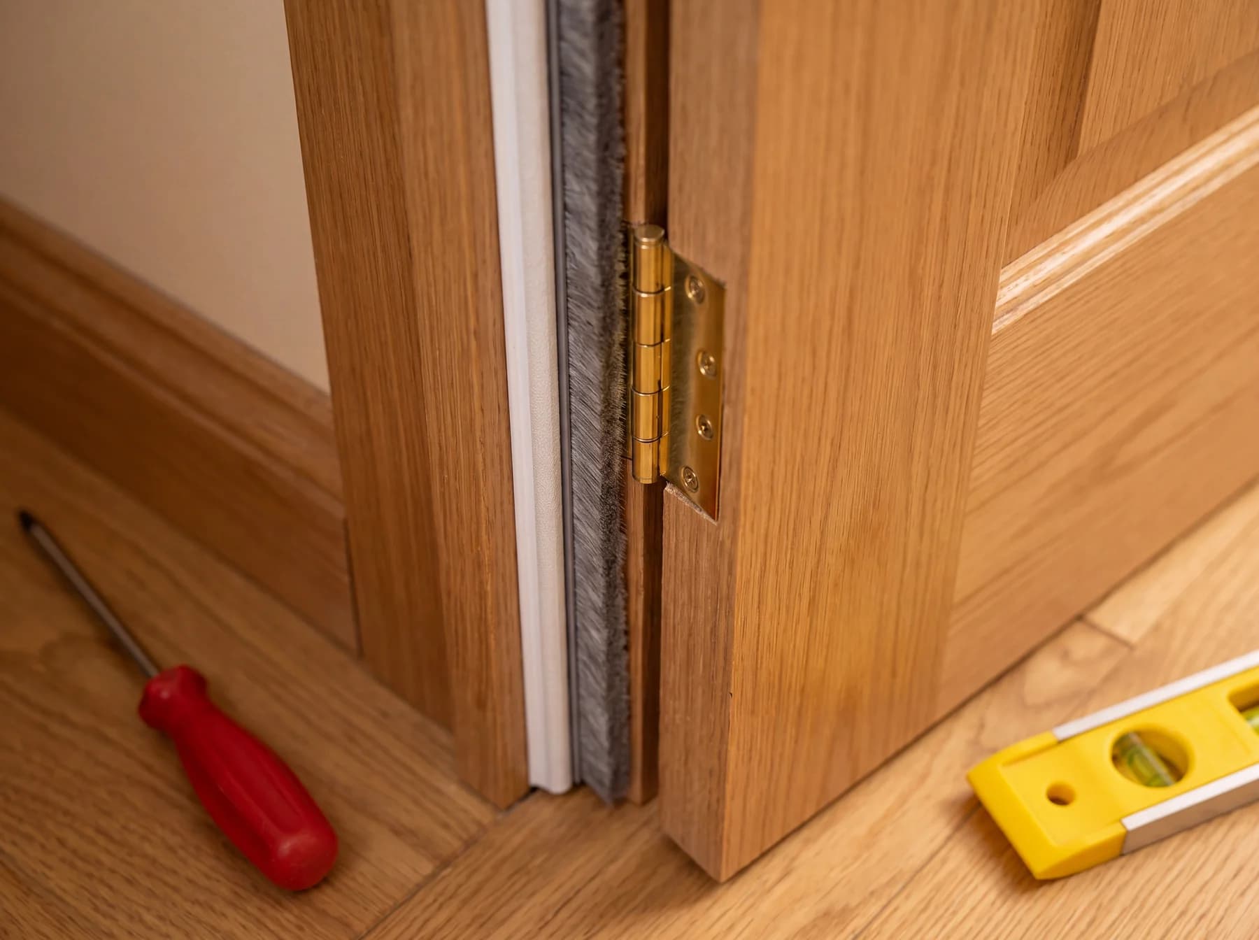 Intumescent strip and smoke seal fitted to a fire door hinge