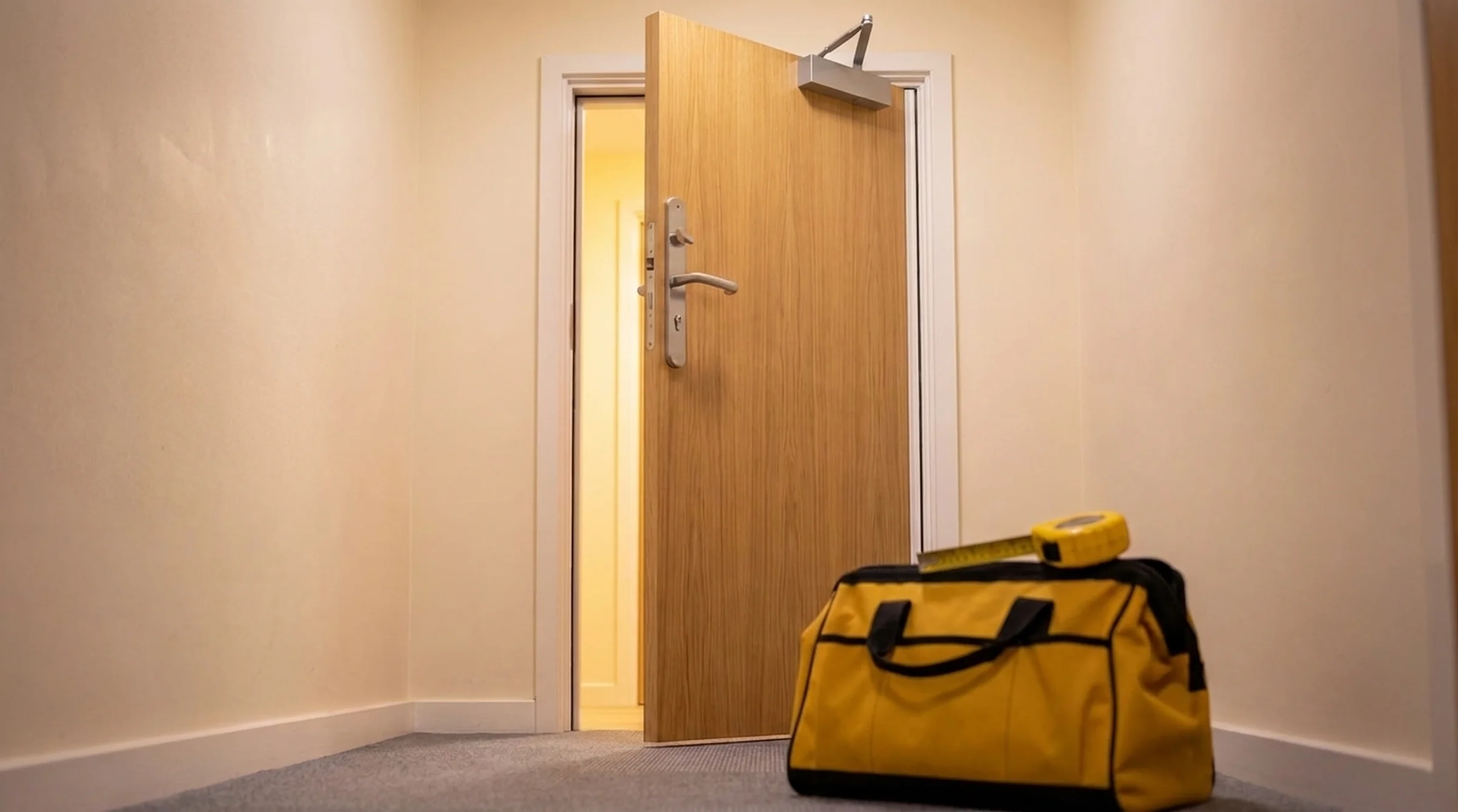 Newly installed FD30 oak veneer fire door with certified door closer and intumescent seal