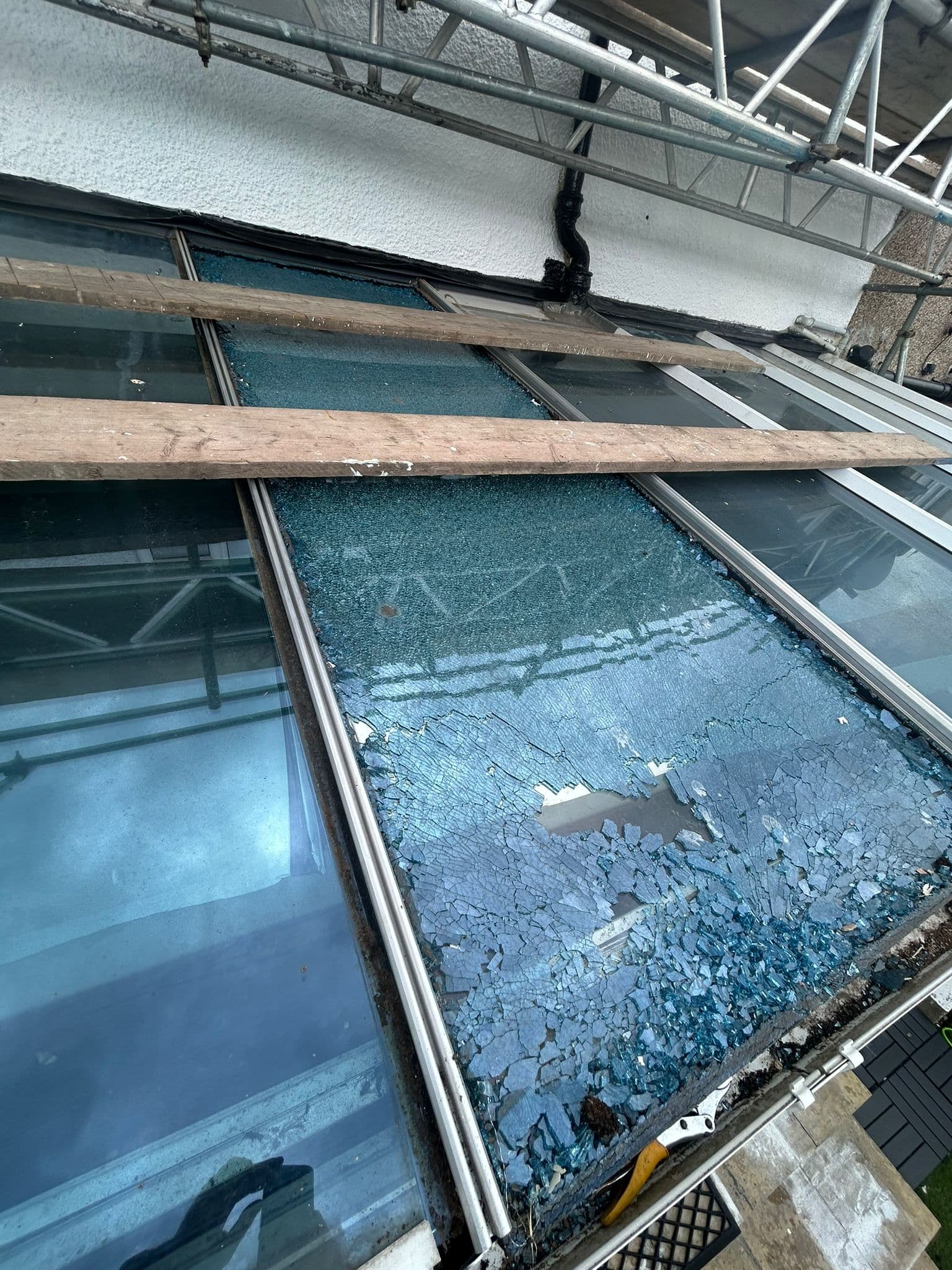 Shattered toughened glass panels on conservatory roof before replacement